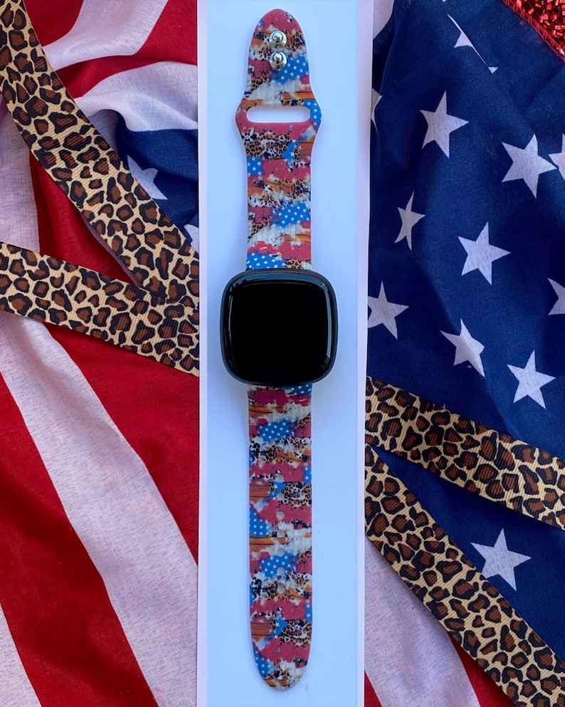 Pu&ograve; includere: Un cinturino per orologio con motivo rosso, bianco e blu con un quadrante nero. Il cinturino &egrave; in silicone e ha un aspetto sportivo.