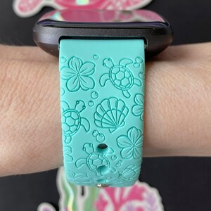 Pu&ograve; includere: Un cinturino per orologio in silicone turchese con un design a tartaruga marina e conchiglia. Il cinturino &egrave; compatibile con gli smartwatch.