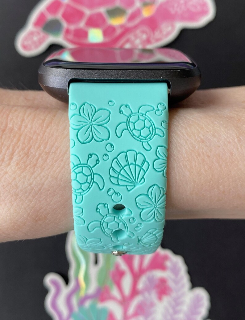 Pu&ograve; includere: Un cinturino per orologio in silicone turchese con un design a tartaruga marina e conchiglia. Il cinturino &egrave; compatibile con gli smartwatch.