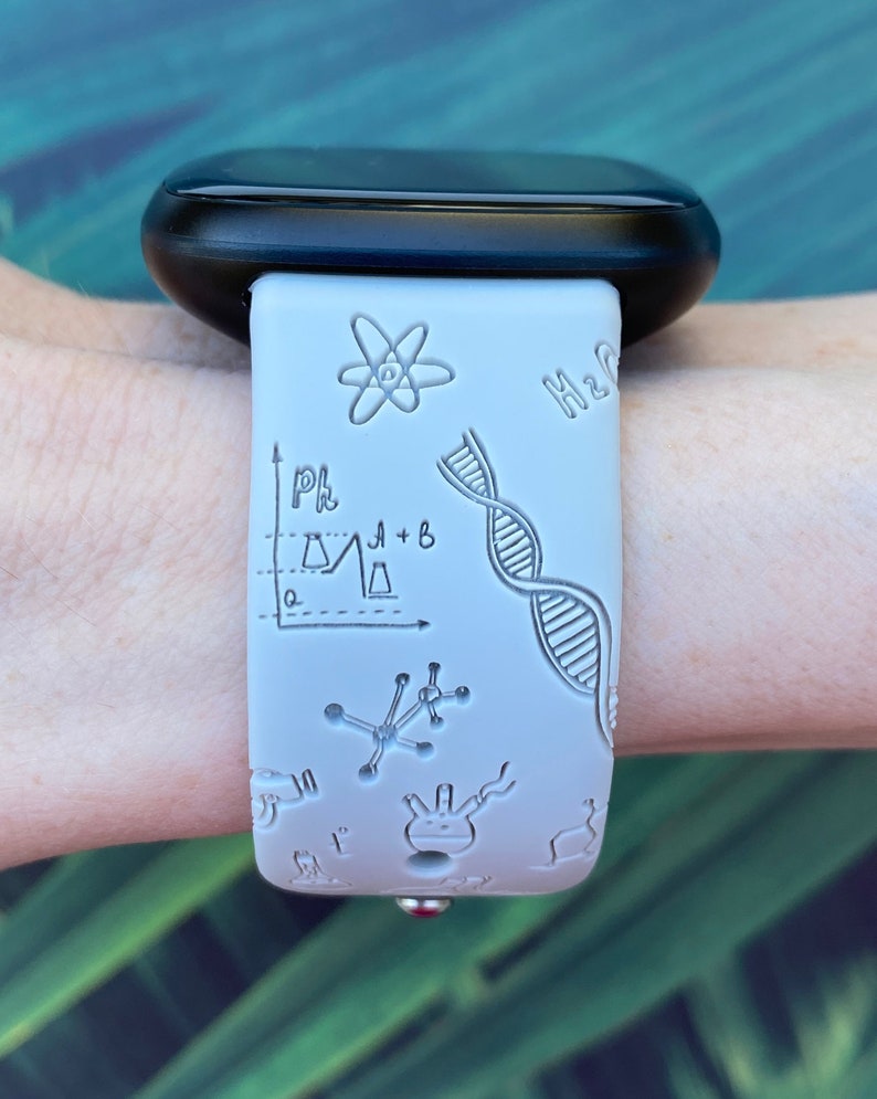 Pu&ograve; includere: Cinturino per orologio in silicone bianco a tema scientifico. Il cinturino presenta una variet&agrave; di illustrazioni scientifiche, tra cui una catena di DNA, un atomo, una beuta e un grafico. Il testo "H2O" &egrave; anche visibile sul cinturino.