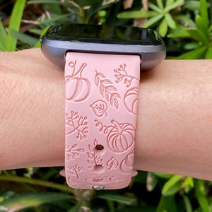 K&ouml;nnte beinhalten: Ein rosafarbenes Silikon-Armband mit einem Herbst-Design mit K&uuml;rbissen und Bl&auml;ttern. Das Armband ist mit einer Smartwatch kompatibel.