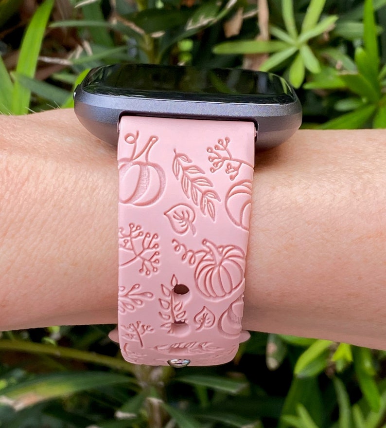 K&ouml;nnte beinhalten: Ein rosafarbenes Silikon-Armband mit einem Herbst-Design mit K&uuml;rbissen und Bl&auml;ttern. Das Armband ist mit einer Smartwatch kompatibel.