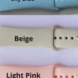Może przedstawiać: Trzy silikonowe paski do zegarka w kolorze jasnoniebieskim, beżowym i jasnor&oacute;żowym. Paski są przeznaczone do smartwatchy i mają zapięcie na klamrę.
