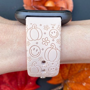 Pu&ograve; includere: Un cinturino per orologio in silicone rosa con un motivo di zucche, faccine sorridenti e fiori. Il cinturino &egrave; progettato per uno smartwatch.
