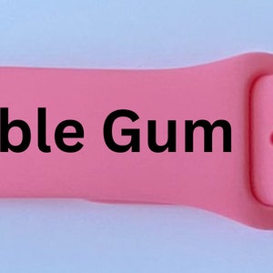 K&ouml;nnte beinhalten: Rosafarbenes Apple Watch Armband mit dem aufgedruckten Text "Bubble Gum".