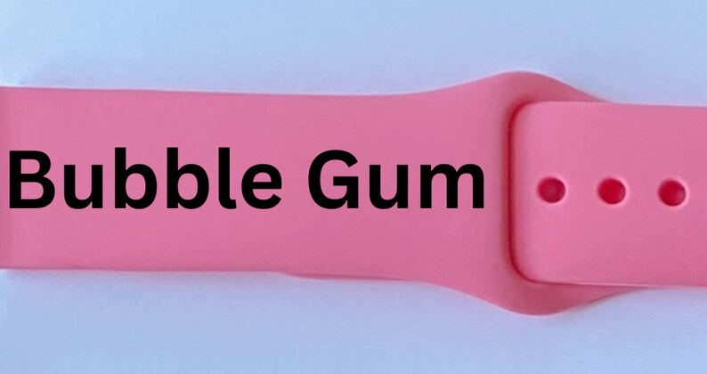 K&ouml;nnte beinhalten: Rosafarbenes Apple Watch Armband mit dem aufgedruckten Text "Bubble Gum".