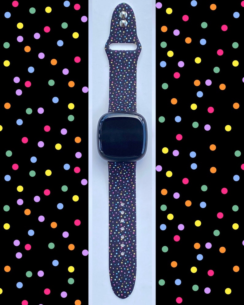 May include: A black smartwatch with a colorful confetti patterned band. The band has small dots of pink, blue, green, yellow, and orange.