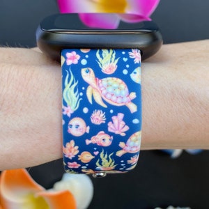 May include: A blue silicone watch band with a colorful sea turtle, fish, and coral design.