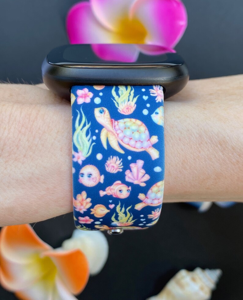 May include: A blue silicone watch band with a colorful sea turtle, fish, and coral design.