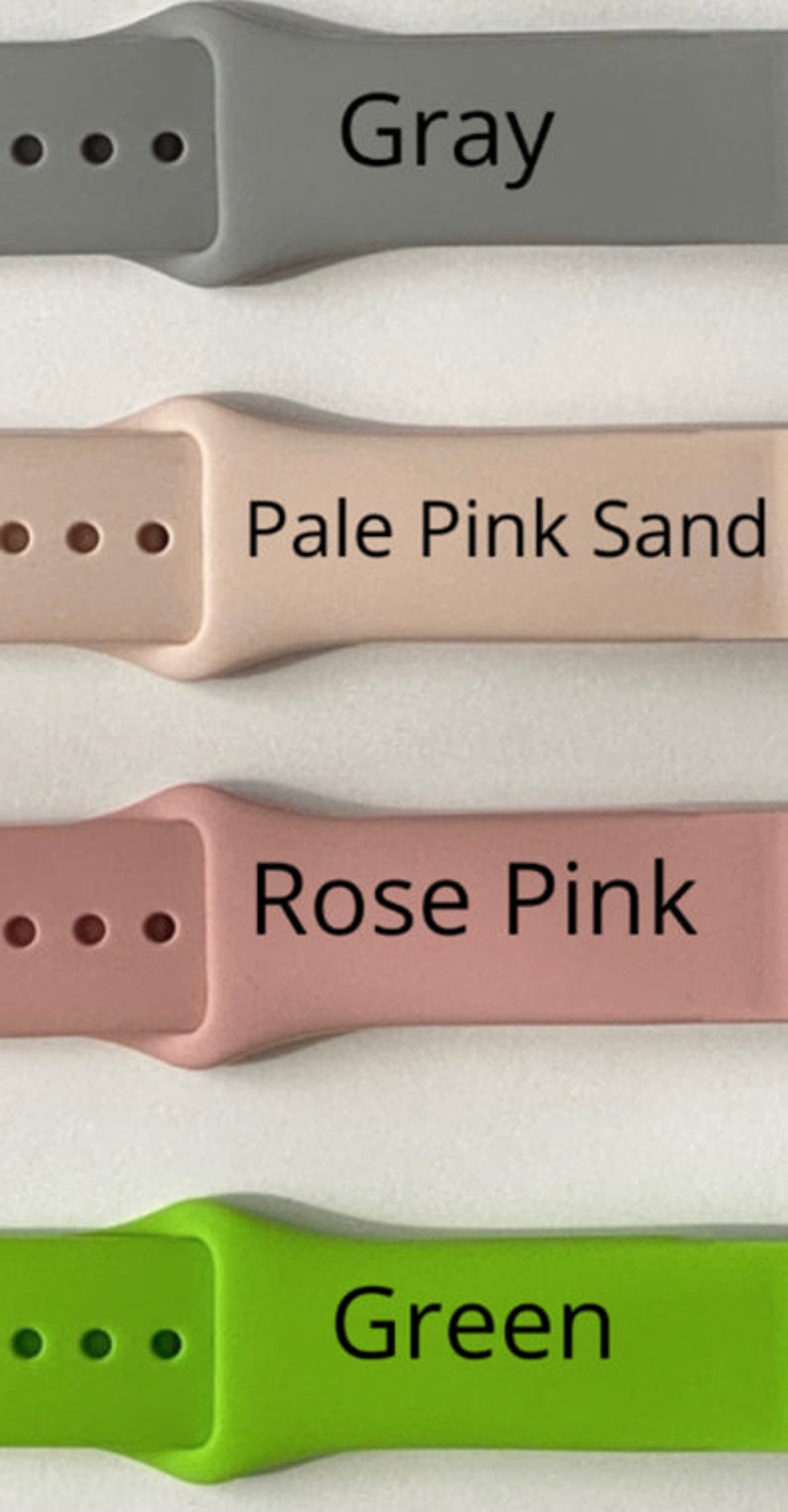 Puede incluir: Cuatro correas para Apple Watch en diferentes colores: gris, rosa p&aacute;lido arena, rosa y verde. Cada correa tiene una hebilla y cuatro agujeros.