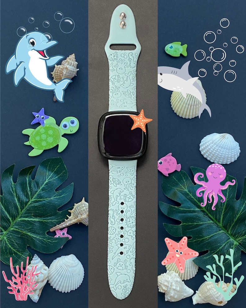 May include: A light blue silicone watch band with a white outline of sea creatures. The band is on a gray background with seashells, starfish, and other sea creatures.