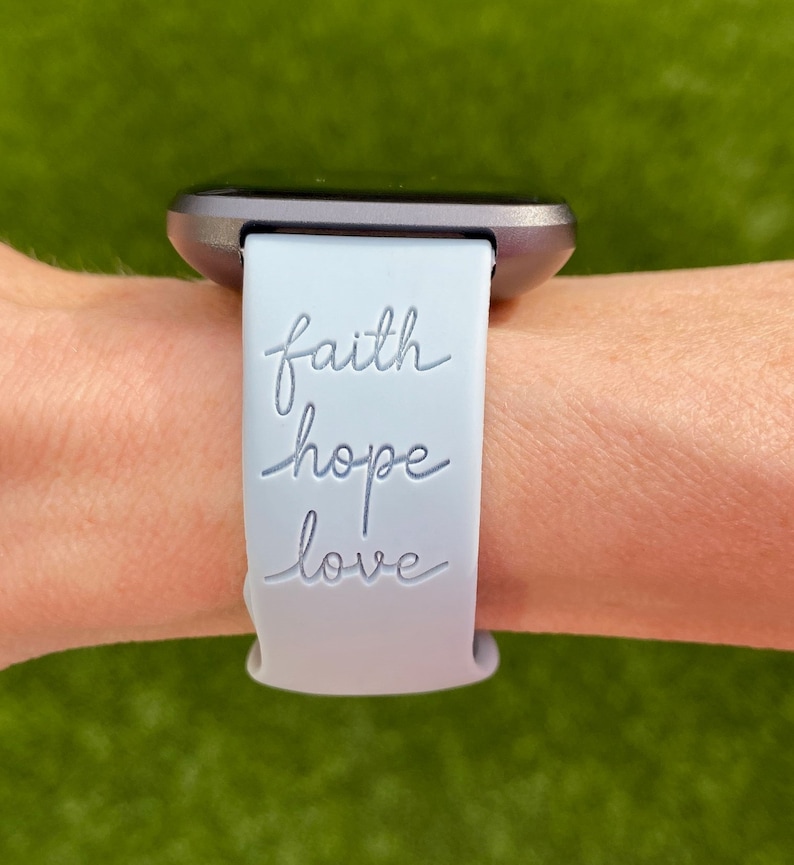 May include: A light blue silicone watch strap with the words "faith hope love" engraved on it.