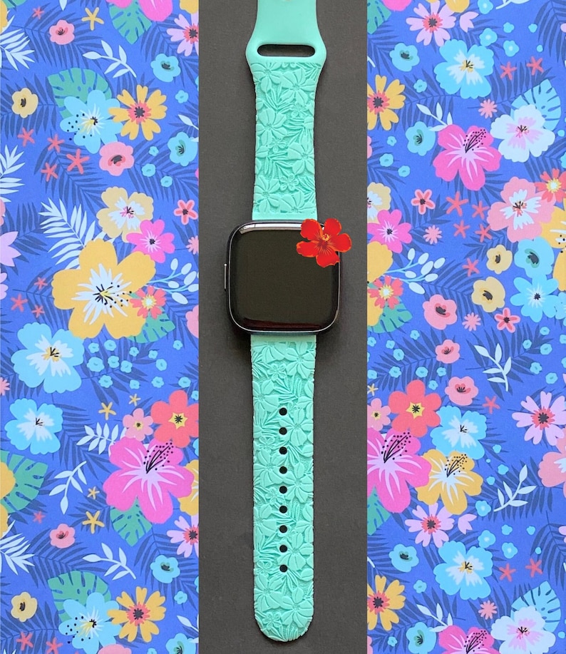 May include: A turquoise blue Apple Watch band with a floral pattern. The band is made of silicone and has a textured surface.