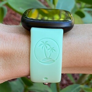 May include: A light green watch strap with a palm tree design. The strap is made of silicone and has a smooth finish.