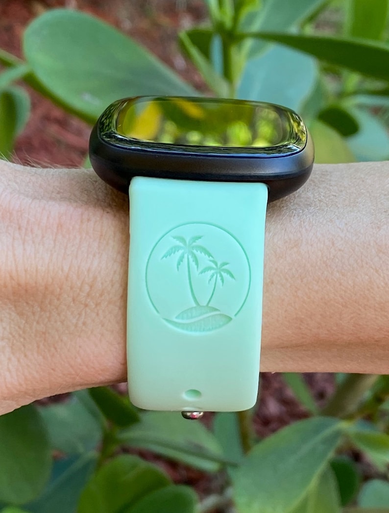 May include: A light green watch strap with a palm tree design. The strap is made of silicone and has a smooth finish.