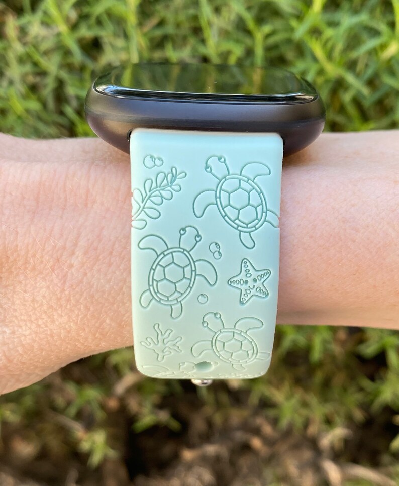 May include: A light green silicone watch band with a sea turtle and starfish design.