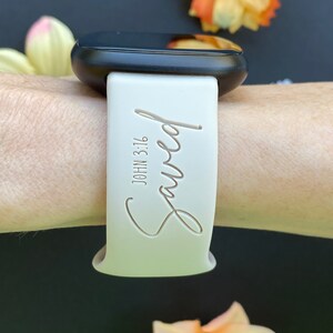 May include: White silicone watch band with the words "Saved" and "John 3:16" engraved on it.