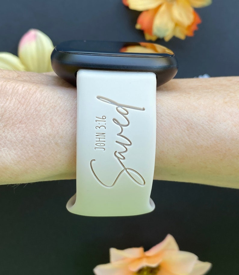 May include: White silicone watch band with the words "Saved" and "John 3:16" engraved on it.