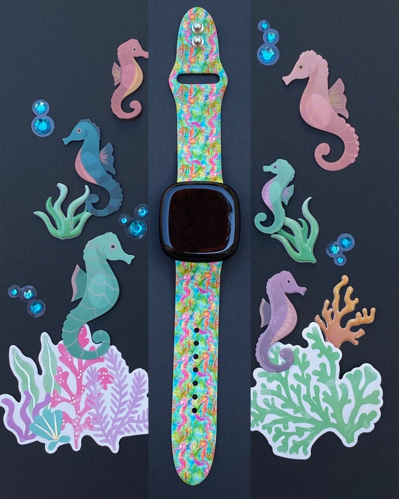 Puede incluir: Una correa de reloj colorida con un patr&oacute;n de caballitos de mar. La correa est&aacute; hecha de silicona y tiene una hebilla negra. La correa est&aacute; decorada con caballitos de mar, conchas marinas y burbujas. La correa de reloj es una excelente manera de agregar un toque de fantas&iacute;a a tu mu&ntilde;eca.