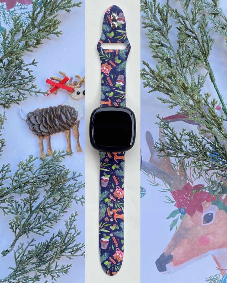 May include: A Christmas-themed watch band with a blue background and a pattern of red and green ornaments, reindeer, and cinnamon sticks. The band is made of silicone and is compatible with smartwatches.