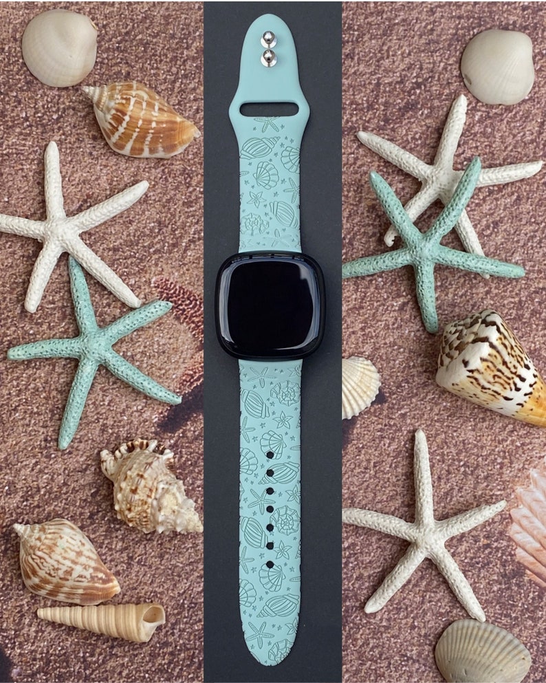 May include: A light blue Apple Watch band with a seashell and starfish pattern. The band is made of silicone and has a black watch face.