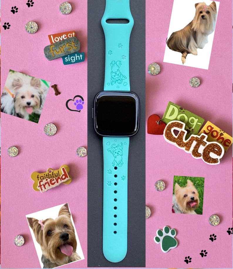 May include: A turquoise blue silicone watch band with a small Yorkshire Terrier dog engraved on it. The band has a black watch face and is surrounded by various dog-themed decorations, including paw prints, hearts, and a sign that says "Dog Gone Cute".