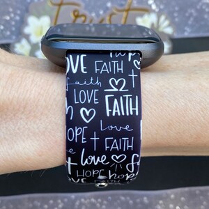 K&ouml;nnte beinhalten: Schwarz-wei&szlig; gemustertes Armband mit den Worten "Love", "Faith" und "Hope", die in handschriftlicher Form wiederholt werden.