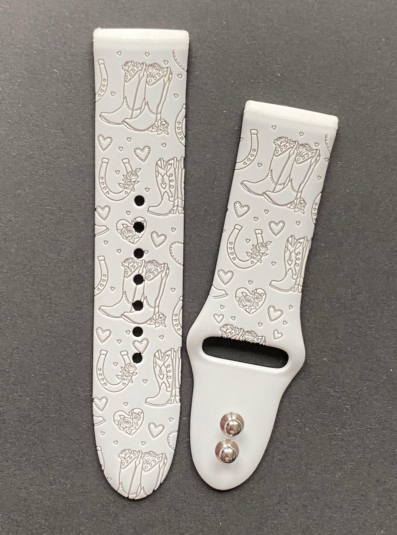 May include: White silicone watch band with a pattern of cowboy boots, horseshoes, and hearts. The band is designed for a smartwatch.