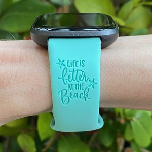 May include: A turquoise silicone watch band with the text "Life is better at the beach" and a starfish graphic.