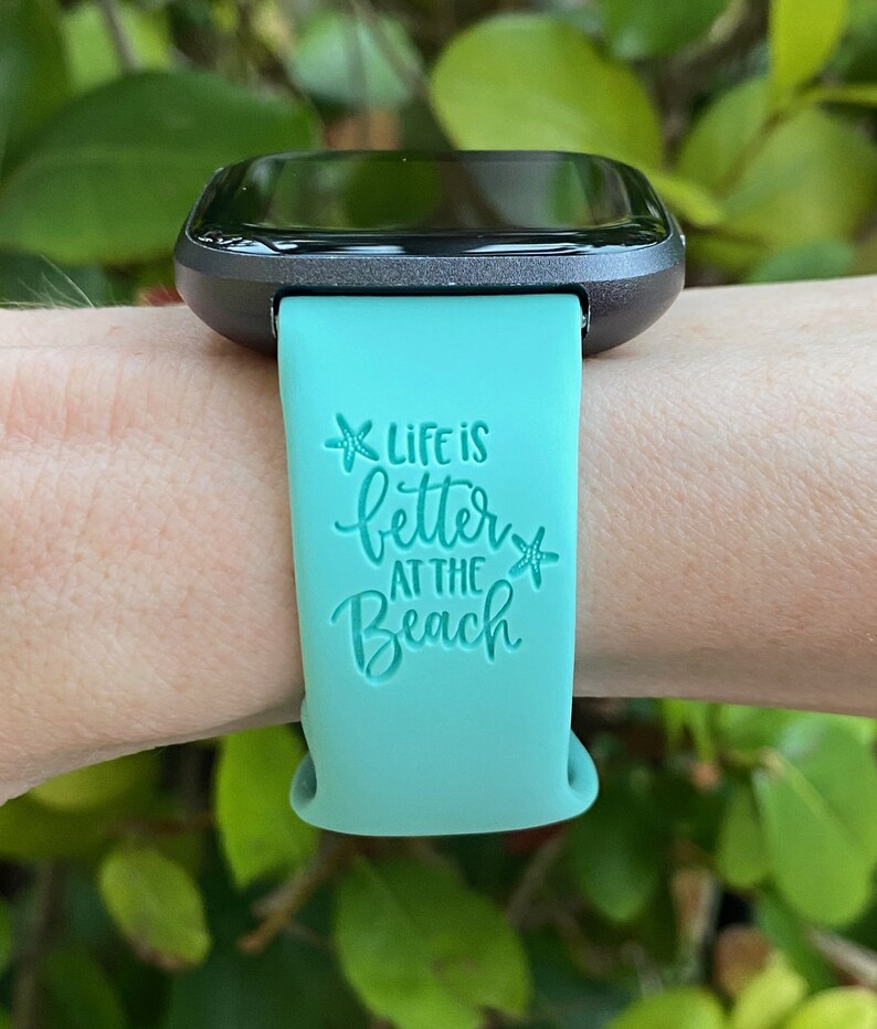 May include: A turquoise silicone watch band with the text "Life is better at the beach" and a starfish graphic.