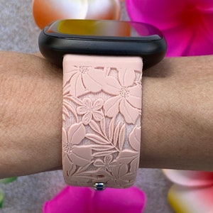 Puede incluir: Una correa de reloj de silicona rosa con un dise&ntilde;o floral. La correa est&aacute; estampada con un patr&oacute;n de flores y hojas.
