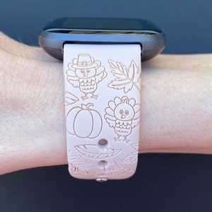 May include: A pink silicone watch band with a Thanksgiving theme. The band features a pattern of turkeys, pumpkins, and leaves.