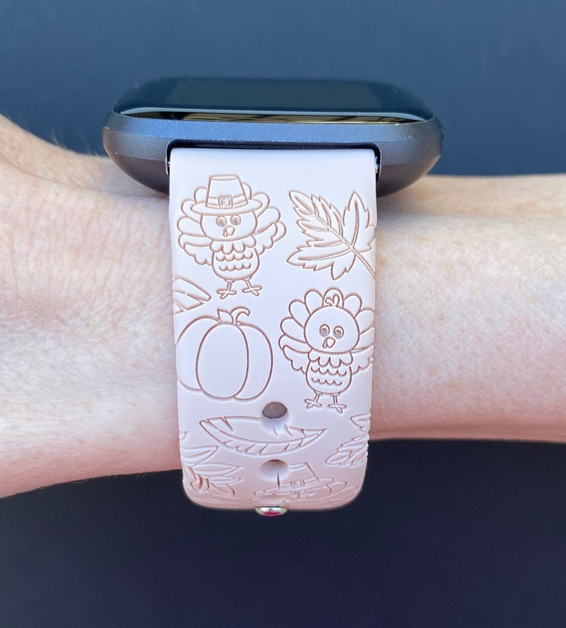 May include: A pink silicone watch band with a Thanksgiving theme. The band features a pattern of turkeys, pumpkins, and leaves.