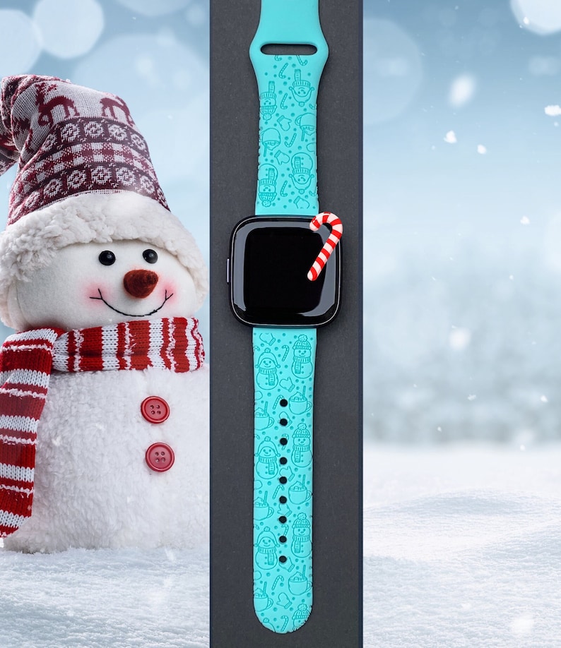 May include: A turquoise blue Apple Watch band with a snowman and candy cane pattern. The band is on a black background.
