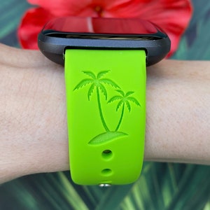 May include: A green silicone watch band with a palm tree design. The band is compatible with smartwatches.