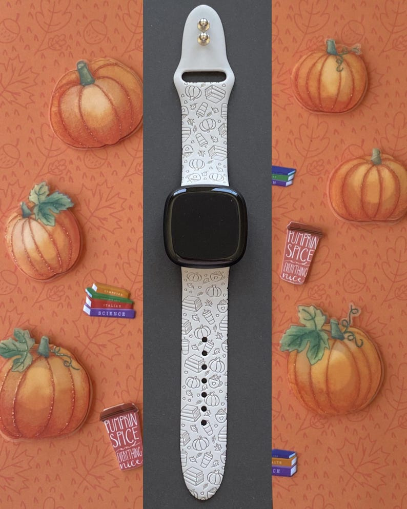 May include: A white smartwatch band with a black watch face, featuring a repeating pattern of pumpkins, books, and coffee cups. The band is surrounded by pumpkin and leaf illustrations on an orange background. The words "Pumpkin Spice Everything Nice" are on a small brown cup.
