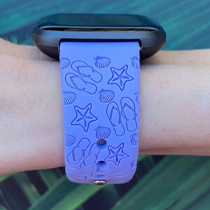 May include: A purple silicone watch band with a beach-themed design featuring flip flops, seashells, and starfish.
