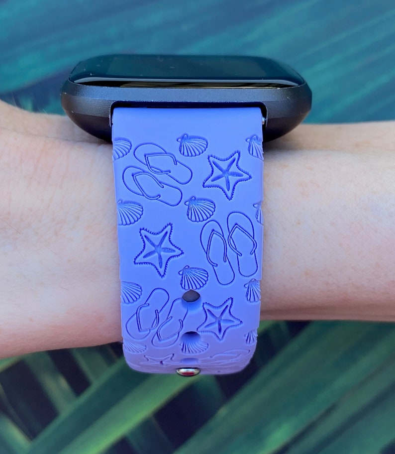 May include: A purple silicone watch band with a beach-themed design featuring flip flops, seashells, and starfish.