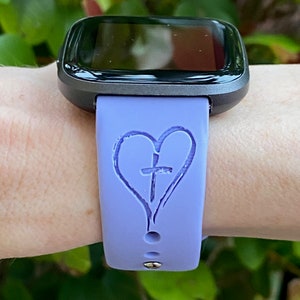 May include: A purple silicone watch band with a heart and cross design.