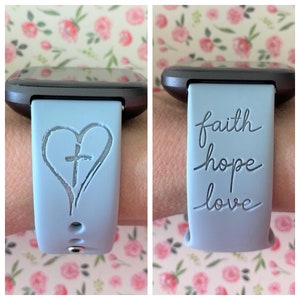 May include: A light blue silicone watch band with a heart and cross design on one side and the words "faith hope love" on the other side.