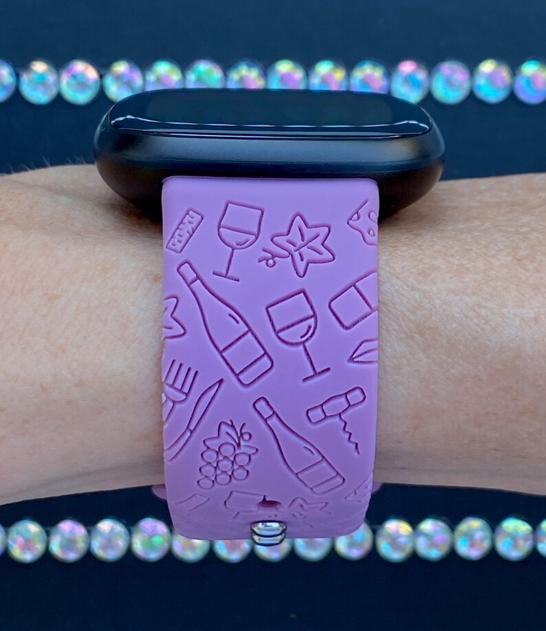 May include: A purple silicone watch band with a wine-themed design. The band features embossed images of wine bottles, glasses, grapes, and corkscrews.