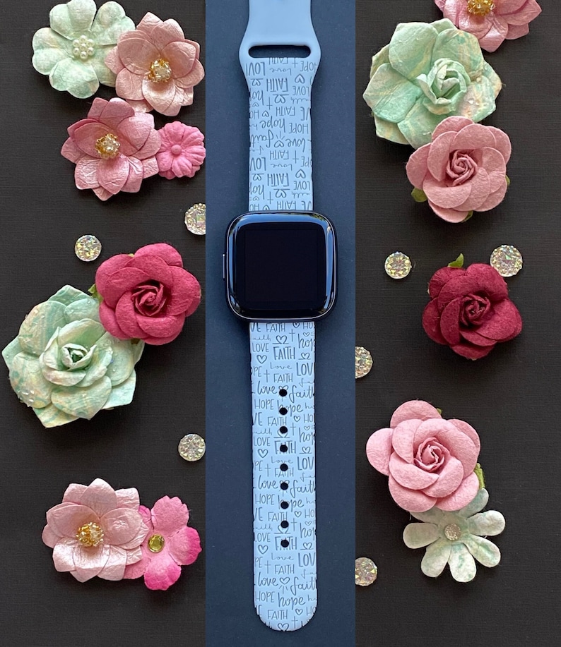 Puede incluir: Una correa de reloj de silicona azul claro con un patr&oacute;n repetido de las palabras "love", "faith" y "hope" en letras blancas. La correa est&aacute; dise&ntilde;ada para un reloj inteligente.