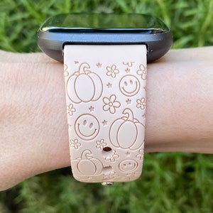 Pu&ograve; includere: Un cinturino per orologio in silicone rosa con un motivo di zucche, faccine sorridenti e fiori. Il cinturino &egrave; progettato per uno smartwatch.