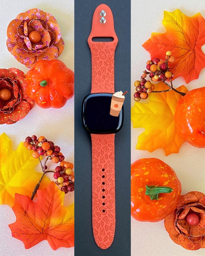 May include: A coral orange silicone watch band with a fall-themed design featuring pumpkins, leaves, and coffee cups. The band is compatible with Apple Watch.