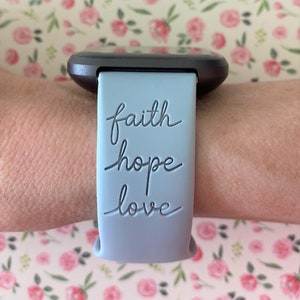 May include: A light blue silicone watch strap with the words "faith hope love" embossed in black.
