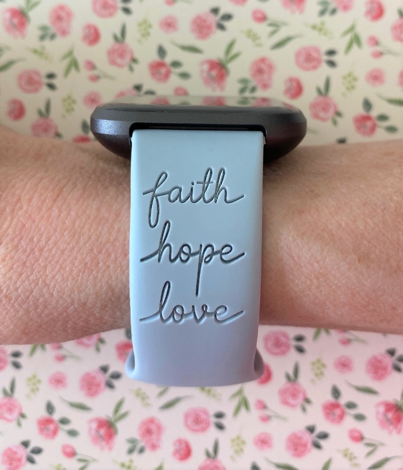 May include: A light blue silicone watch strap with the words "faith hope love" embossed in black.