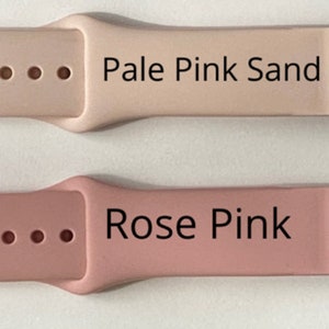 Puede incluir: Cuatro correas para Apple Watch en diferentes colores: gris, rosa p&aacute;lido arena, rosa y verde. Cada correa tiene una hebilla y cuatro agujeros.