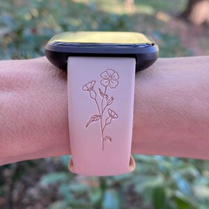 Op de afbeelding: Een roze siliconen horlogeband met een bloemenpatroon. De band is compatibel met smartwatches.