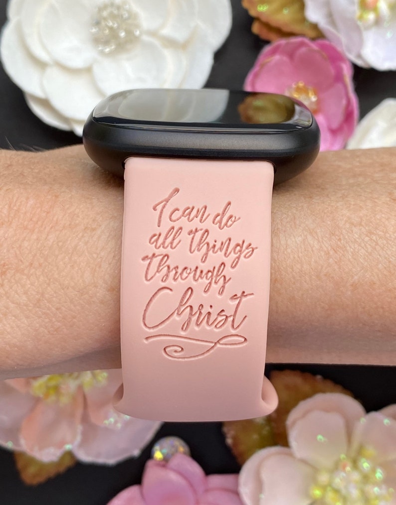 May include: A pink silicone watch band with the text "I can do all things through Christ" in a cursive font.