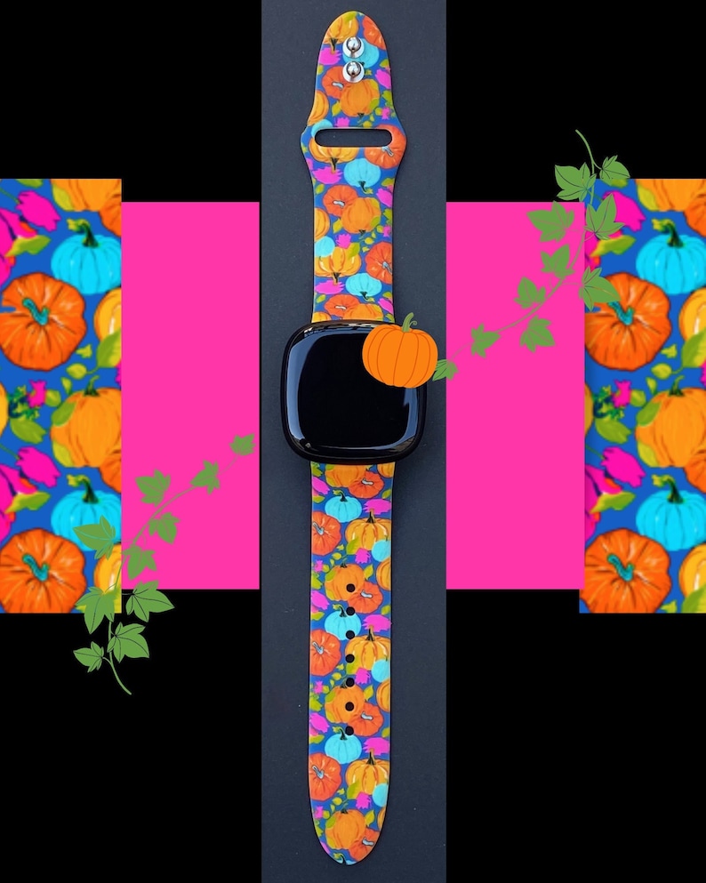 May include: A black smartwatch with a pumpkin-themed silicone band. The band features a repeating pattern of orange, blue, and pink pumpkins on a dark blue background.